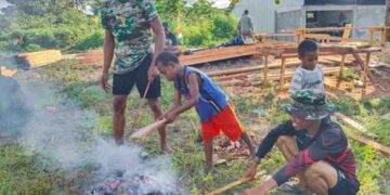 Personel TMMD Ke-128 Kodim 1801 Manokwari Bakar Singkong dan Bercanda Bersama Warga